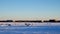 Car drives past Winter Fishing Houses on frozen Lake Bemidji in Minnesota.