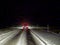 A car drives slowly at night on a slippery snowy road in the USA