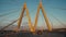 Car drives under bridge pylons in letter M shape in evening