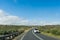 Car driving along curving coastal road on sunny day