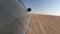 Car is driving in the desert. Camera from the car`s right side