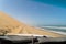 Car driving at dirt road in desert. Sand drive at the beach. Coast of sea.