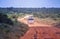 The car is driving on a dirt road in Tsavo National Park East Kenya. People are on a safari trip in nature.