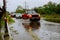 Car driving through flood water the road during monsoon season