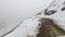 Car driving in himalayan snow cap mountains at morning in slushy tarmac road