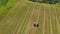 The car is driving next to the combine, loading the crop, aerial view.