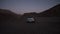 Car driving off road, turning and stopping. Tracking of small silver SUV. Evening footage after sunset. Marrakesh