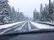 Car driving on snow-covered snowy mountain road in winter snow. Driver`s point of view viewpoint looking through windshield.