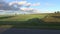 Car evening shadow on fields near highway