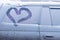Car with frozen windows and a heart drawn on the glass.