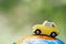 A car on globe on green background. Miniature car toy on globe. Travel concept