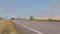 The car goes on a country road between pshenichnyh fields. Car at sunset, against a background of wheat field