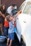 This car is going to be squeaky clean. a family washing their car in the driveway.