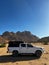 Car on gravel dirt road in desert. Sandy landscape, nobody. SUV.