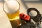 car and handcuffs and cup of beer in jail close up concept of illegal drunk driving