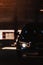 Car headlight of powerful sports black car on dark background. Car headlight at night.