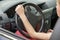 Car interior. Dashboard and woman hands on steering wheel driving a car