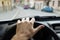 Car interior - hand on steering wheel with blurred cars on street