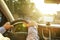 Car interior with male driver sitting behind the wheel, soft sunset light. Luxurious vehicle dashboard and electronics.