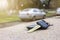 Car key fall on the asphalt road. Driver lost his vehicle keys and walks away. Misfortune concept. Blurred foreground and