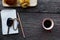 Car key on notepad with pencil and red coffee cup and bun bread on wood table backgrounds above