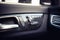 car leather interior details of door handle with windows controls, seat adjustments. modern window and door controls of car