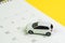 Car loan payment, buying new car or yearly maintenance schedule concept, miniature white car on clean calendar with date on yellow