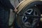 A car mechanic changes a tire on a wheel