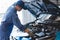 Car mechanic checking to maintenance vehicle by customer claim order in auto repair shop garage by list in clipboard. Engine