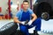 Car mechanic crouching down by a pair of wheels