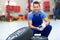 Car mechanic crouching down by a pair of wheels