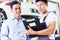 Car mechanic and customer in Asian auto workshop