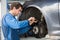 Car Mechanic Examining Brake Disc With Caliper