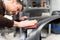 Car mechanic grinds a car part in handicraft in a service station - Serie car repair workshop