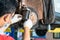 Car mechanic hands replace brakes in garage. Mechanic technician worker installing car wheel at maintenance. Worker changing brake