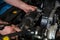 Car mechanic hands replacing engine throttle body.