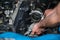 Car mechanic hands replacing engine throttle body.