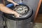 Car mechanic hands sink on water tank the tyre