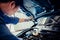 Car mechanic holding checking gear oil to maintenance vehicle by customer claim order in auto repair shop garage. Engine repair