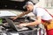 Car mechanic open hood to repair and check car problem system by laptop for maintenance and fixed in garage