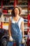 Car mechanic smiling woman with wrenches standing near the car