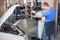 Car mechanic washes the car engine with pressurized water