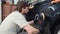 Car mechanic worker hands polishing a car side with a orbital polishing machine.