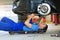 Car mechanic working on the underside of a car