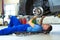 Car mechanic working on the underside of a car