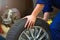 Car mechanic in workshop changing tires