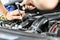 Car mechanic in a workshop - closeup engine repair and diagnosis