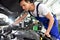 car mechanic in a workshop - engine repair and diagnosis on a vehicle