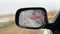 Car mirror covered in snow: Very stormy bad weather with fast hail and rain outdoors
