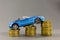 Car model on  background of coins. Concept of leasing, auto loan, auto insurance, taxes